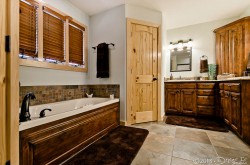 main level master private bath with Jacuzzi tub, separate shower, and dual sinks image 1